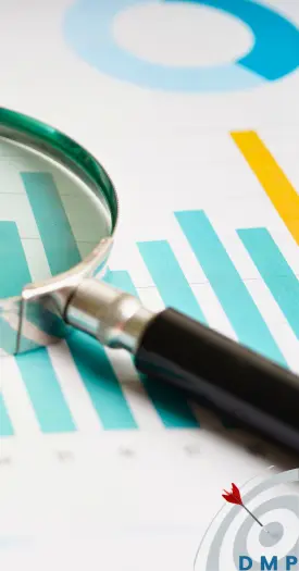 Magnifying glass resting on documents with graphs